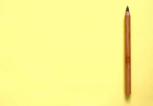 Brown gerecycleerd Eco pen op gele achtergrond. Platte lag. Plaats voor tekst. Eco concept — Stockfoto