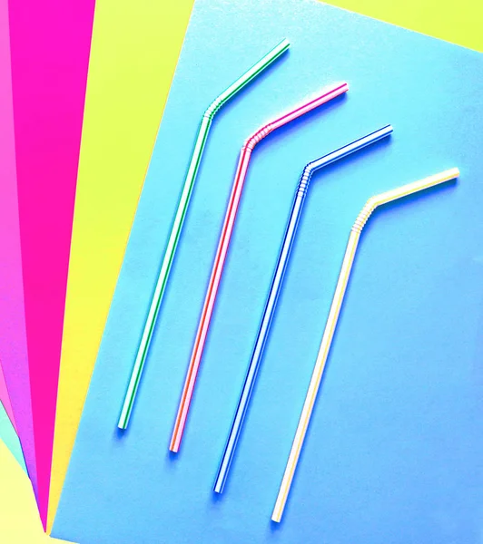 Цветные полосатые пластиковые коктейльные трубки на цветном фоне. Современные и модные цвета. Эко-концепция. Плоский лежал — стоковое фото