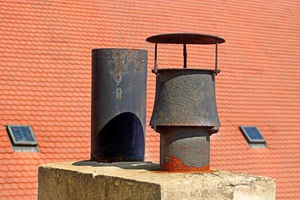 Typical two old metallic pipes and two windows on a tiled roof in european city — Stock Photo, Image