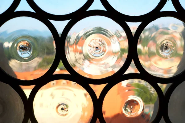 Вид из окна, Братислава, Словакия. Стекло в виде кругов, что вызывает деформацию зрения. Выборочный фокус на стекле и раме окна — стоковое фото