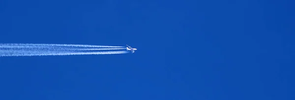 View of white plane flying in blue sky with trail. Banner. Place for text — Stock Photo, Image