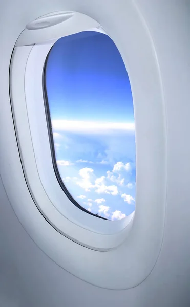 Vista das nuvens através do pórtico da aeronave. Janela de aeronaves. Conceito de viagem — Fotografia de Stock