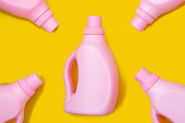 Sarı arka planda pembe şişeler. Temizlik kavramı