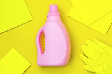 Ortasında pembe şişe, sarı paçavralar, sarı arka planda sarı eldivenler. Temizlik kavramı