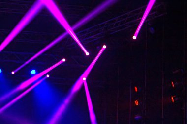 Karanlıkta sahnede mor ve mavi ışık huzmeleri