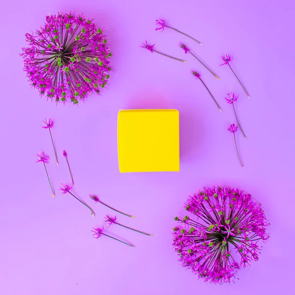 Lila Knoblauchblüten Und Gelbe Schachtel Mit Einem Geschenk Auf Fliederfarbenem — Stockfoto