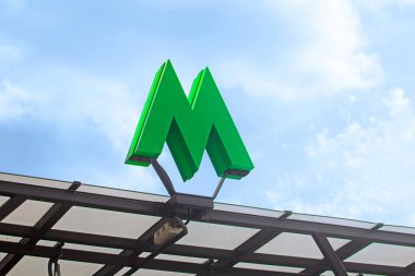 KYIV, UKRAINE - 4 Temmuz 2020: Arkaplan olarak yeşil metro işareti ve mavi gökyüzü