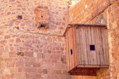Aziz Catherine Manastırı 'nın yüksek taş duvarlarında tahta giriş kapısı, Sina Dağı, Mısır. Yıllar önce bütün kapılar kilitliydi ve giriş bir asansörden yapıldı. Bu da malzeme taşımak için kullanılıyordu.