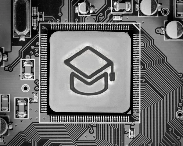 Macro photo of circuit board with education icon on the chip surface; concept of e-learning