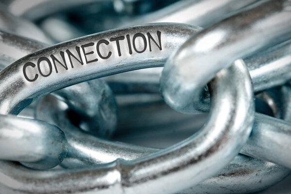 Photo of chains abstract closeup with CONNECTION concept word imprinted on metal surface