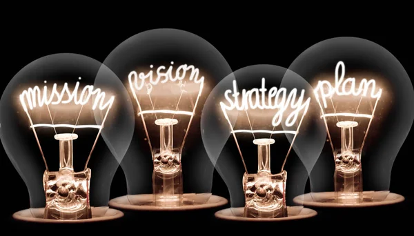 Photo of light bulbs with shining fibers in MISSION, VISION, STRATEGY and PLAN shape on black background