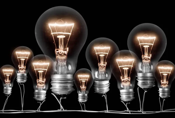 Photo of shining light bulbs; concept of idea and innovation; isolated on black background