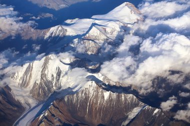 Karla kaplı dağlar ve bulutların üzerinde onları
