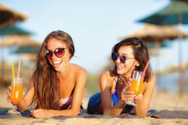 İki seksi kızlar eğleniyor bir sahilde kokteyl içme