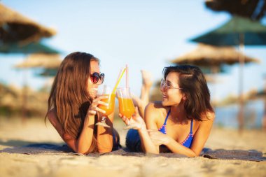 İki seksi kızlar eğleniyor bir sahilde kokteyl içme