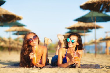 İki seksi kızlar eğleniyor bir sahilde kokteyl içme