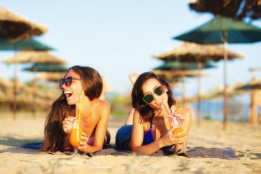İki seksi kızlar eğleniyor bir sahilde kokteyl içme