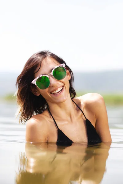 一个性感的女孩与太阳镜在水中的肖像 — 图库照片