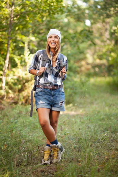 漂亮的女孩徒步旅行者在森林里 戴着帽子 衬衫和短裤 — 图库照片