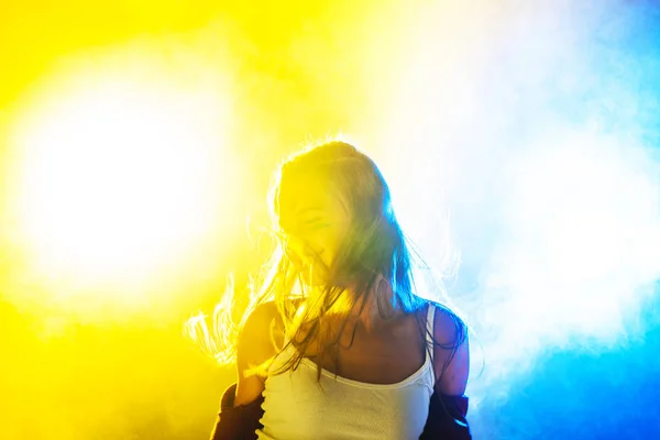 Joven Fiesta Chica Bailando Contra Amarillo Azul Retroiluminado Humo — Foto de Stock