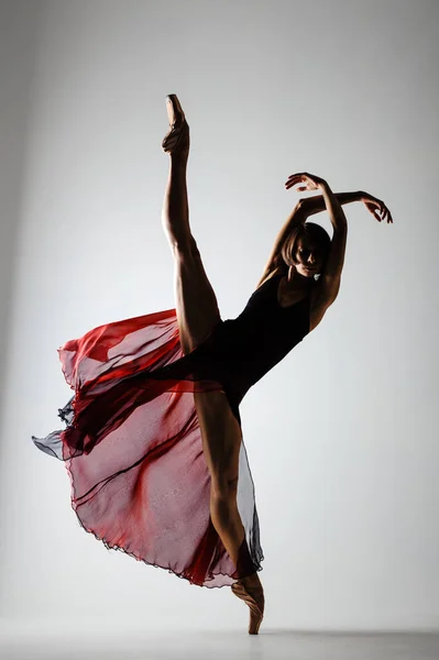 芭蕾演员的半身轮廓 穿着飘扬的红色连衣裙 免版税图库图片