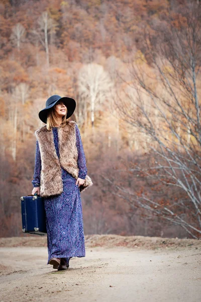 Bella ragazza con caso vintage su un Dirtroad — Foto Stock