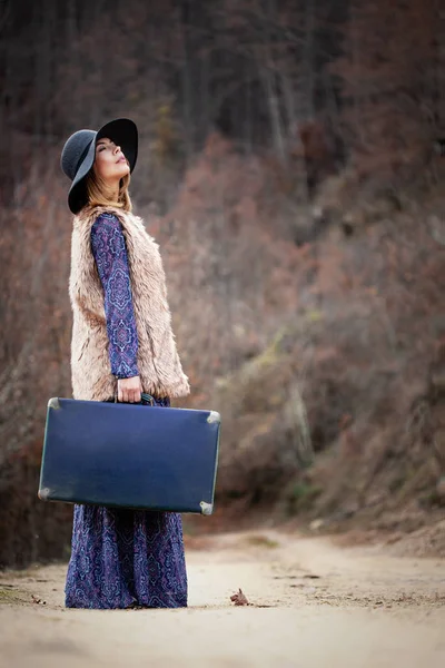 Bella ragazza con caso vintage su un Dirtroad — Foto Stock