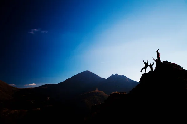 Happy hikers on a rock, silhouette — Stock Photo, Image