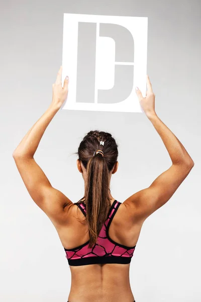 Fit girl holding the letter d — Stock Photo, Image