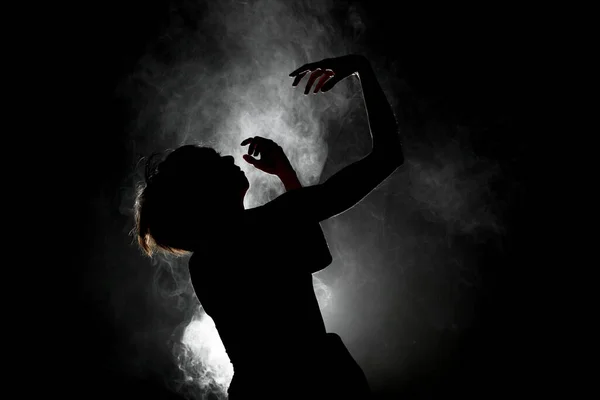 シルエットモダンバレエダンサー煙で暗い背景にポーズ — ストック写真