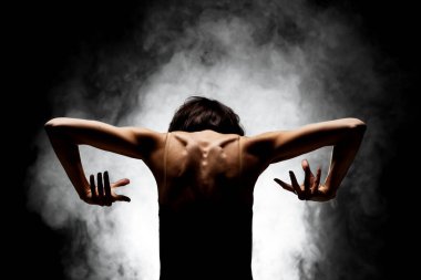 Yarı siluet modern balerin esmer arka planda dumanla poz veriyor.