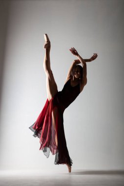 Yarı balerin silueti, el sallayan kırmızı elbiseli.