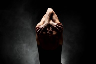 Yarı siluet modern balerin esmer arka planda dumanla poz veriyor.