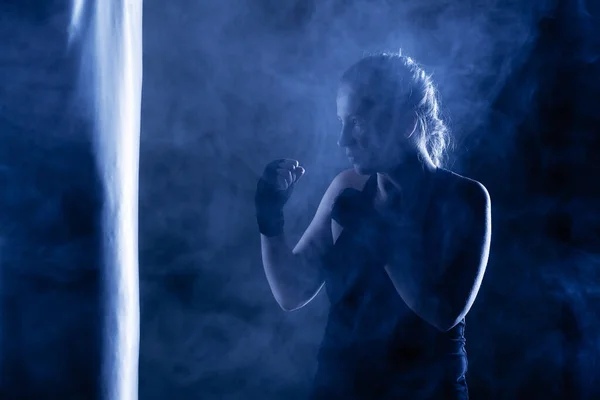 Dziewczyna Kick Fighter Uderzając Worek Bokserski Dym Powietrzu — Zdjęcie stockowe