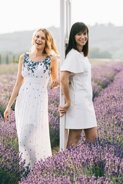 İki genç kadın çiçek alan ayakta, iki kadın yaz keyfini çıkarın