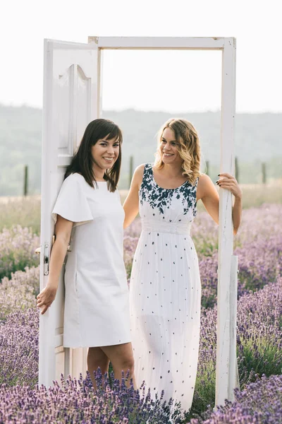 两位年轻女子站在花场上 两个女人享受夏天 — 图库照片