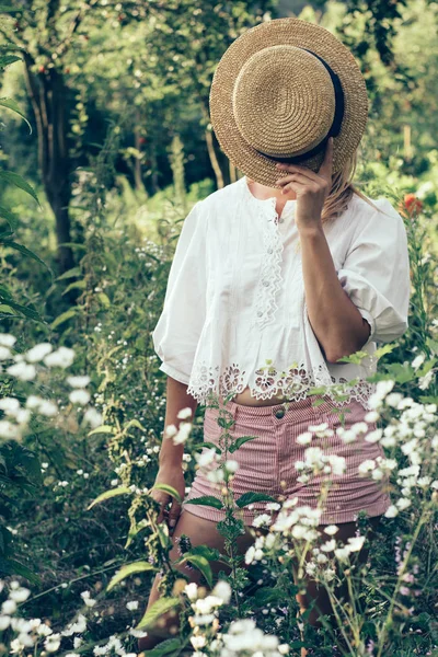 麦わら帽子の後ろに隠れているファッショナブルな女性 — ストック写真