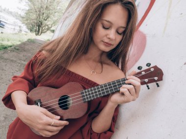 Genç kadın ukulele üzerinde oynama