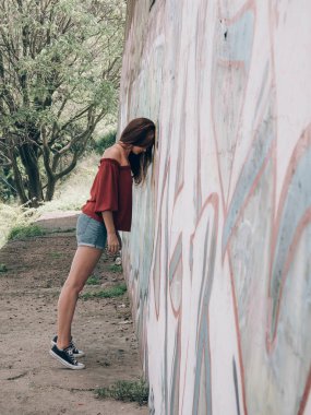 Duvar grafiti ile genç kadın dayanan