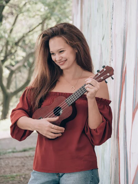 Munter kvinne som spiller på ukulele – stockfoto