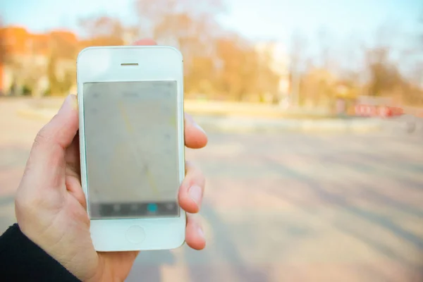 Lburred fondo del hombre sosteniendo su teléfono y mirando en él — Foto de Stock