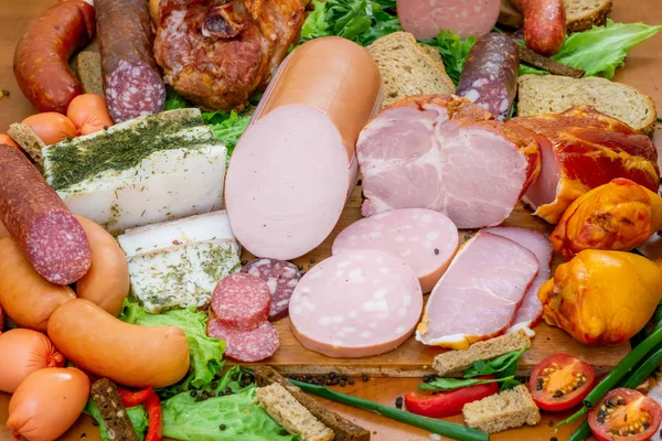 Асорті м'ясних продуктів, включаючи шинку та сосиски — стокове фото