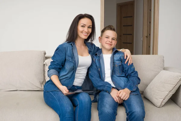 Familia feliz sentado en el sofá y el uso de la tableta digital en casa — Foto de Stock