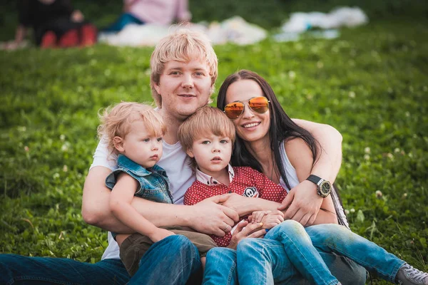 Ευτυχισμένη οικογένεια μαζί στο πάρκο πρασίνου το καλοκαίρι — Φωτογραφία Αρχείου