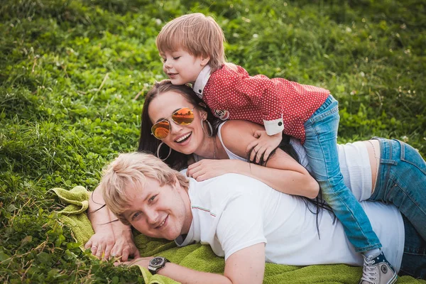 Familia feliz juntos en el parque verde en verano — Foto de Stock