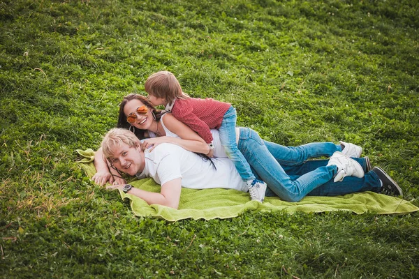 Šťastná rodina pohromadě v zeleném parku v létě — Stock fotografie
