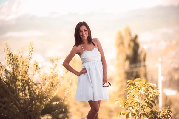 Smiling woman in white dress standing on beautiful crimea background — Stock Photo, Image