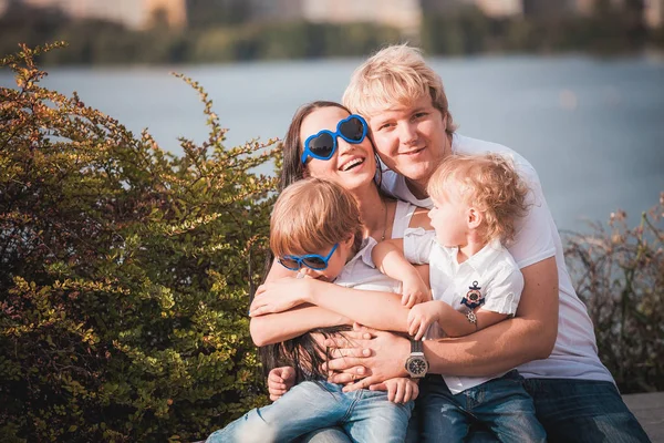 Família feliz juntos contra belo fundo — Fotografia de Stock