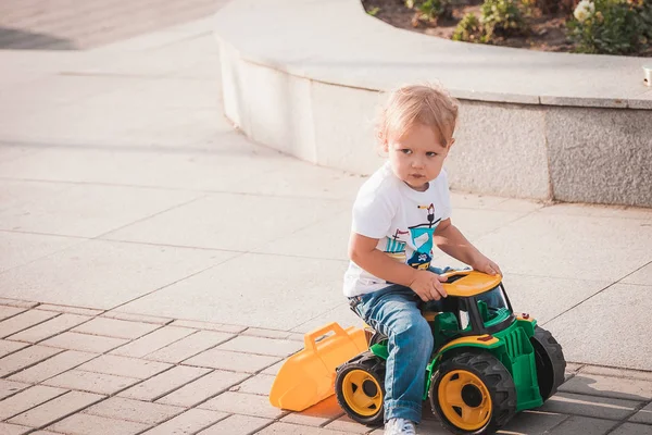Милый мальчик играет с игрушечным трактором — стоковое фото