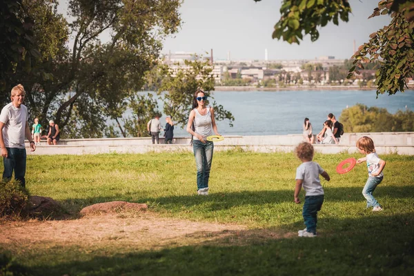 Familia jugando frisbee en el prado en el parque — Foto de Stock
